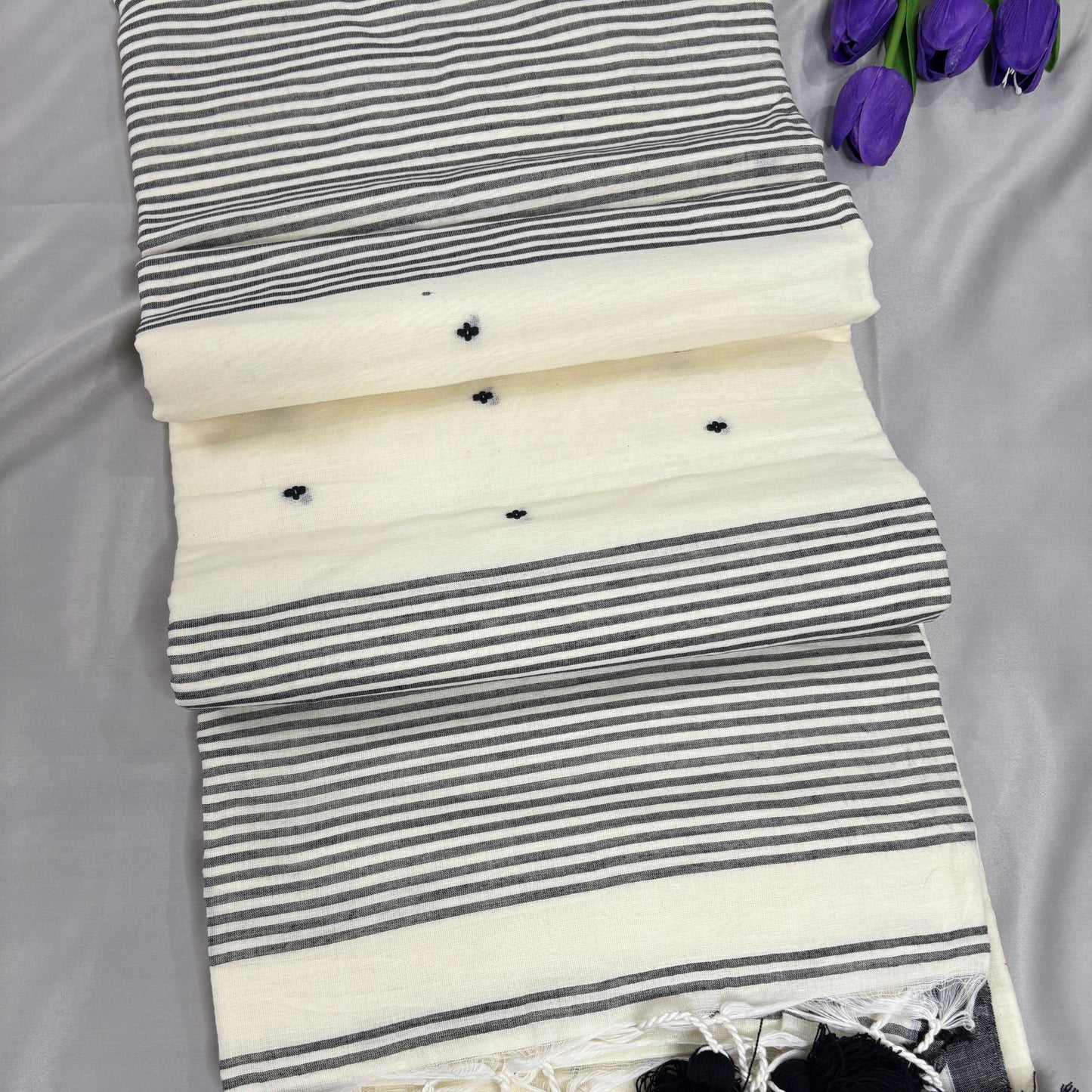 Striped saree with tassels on a gray background