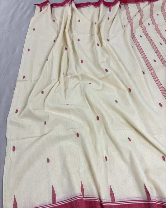 White saree with red border and small red patterns on a gray background