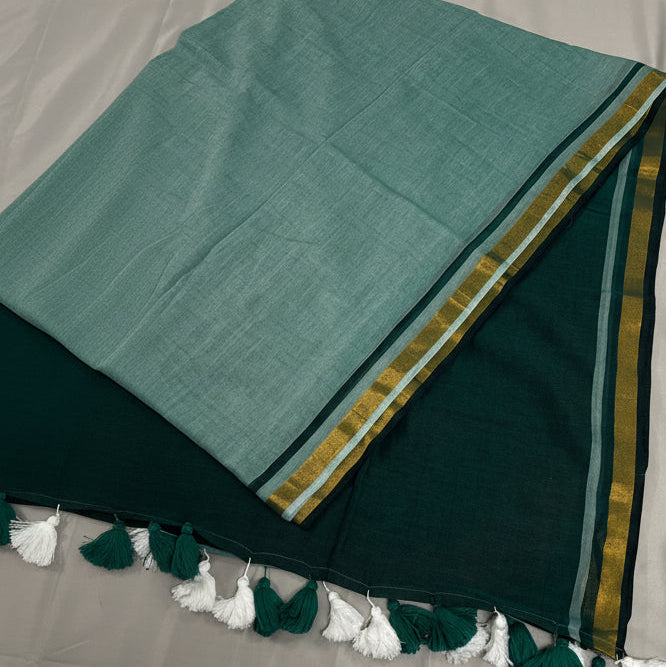 Green and gold traditional fabric with tassels on a gray background