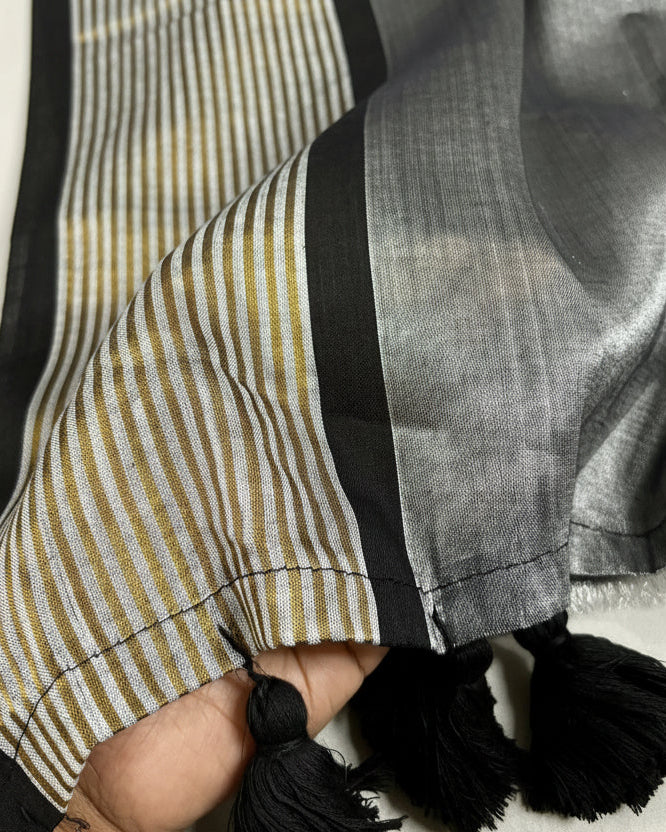 Close-up of a Shuchi label Saree with striped border and tassels on a white background