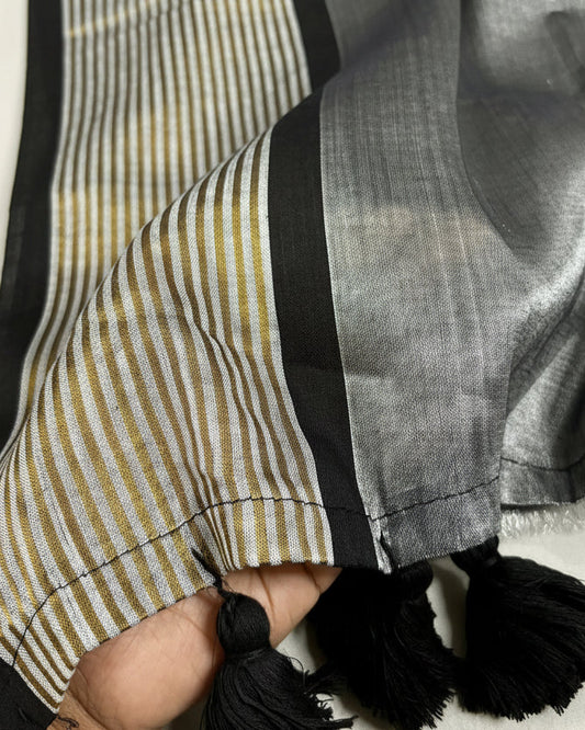 Close-up of a Shuchi label Saree with striped border and tassels on a white background