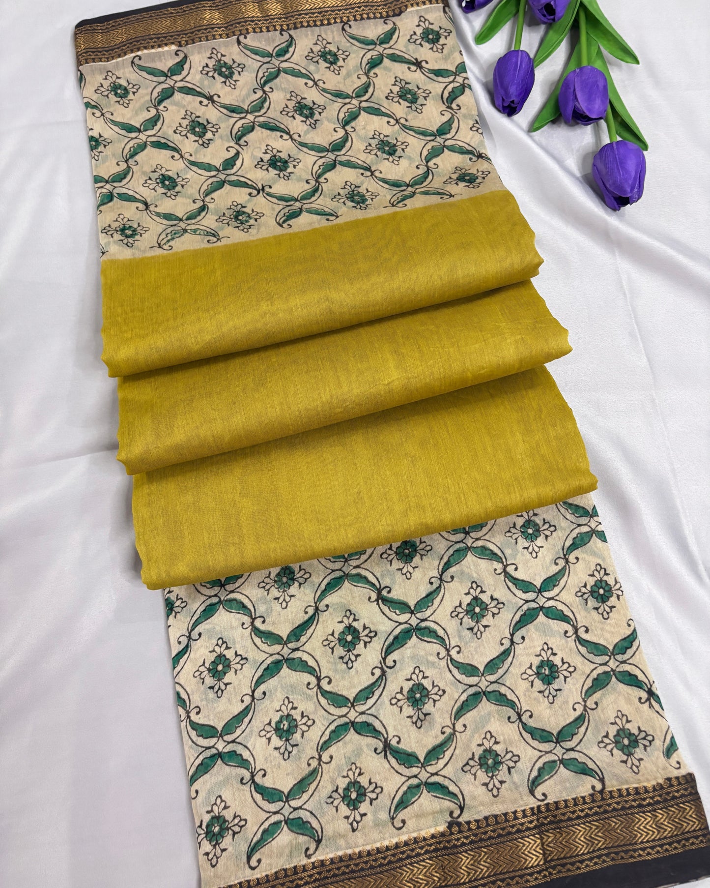 Folded Shuchi Label office wear yellow saree with green and beige pattern on a white background