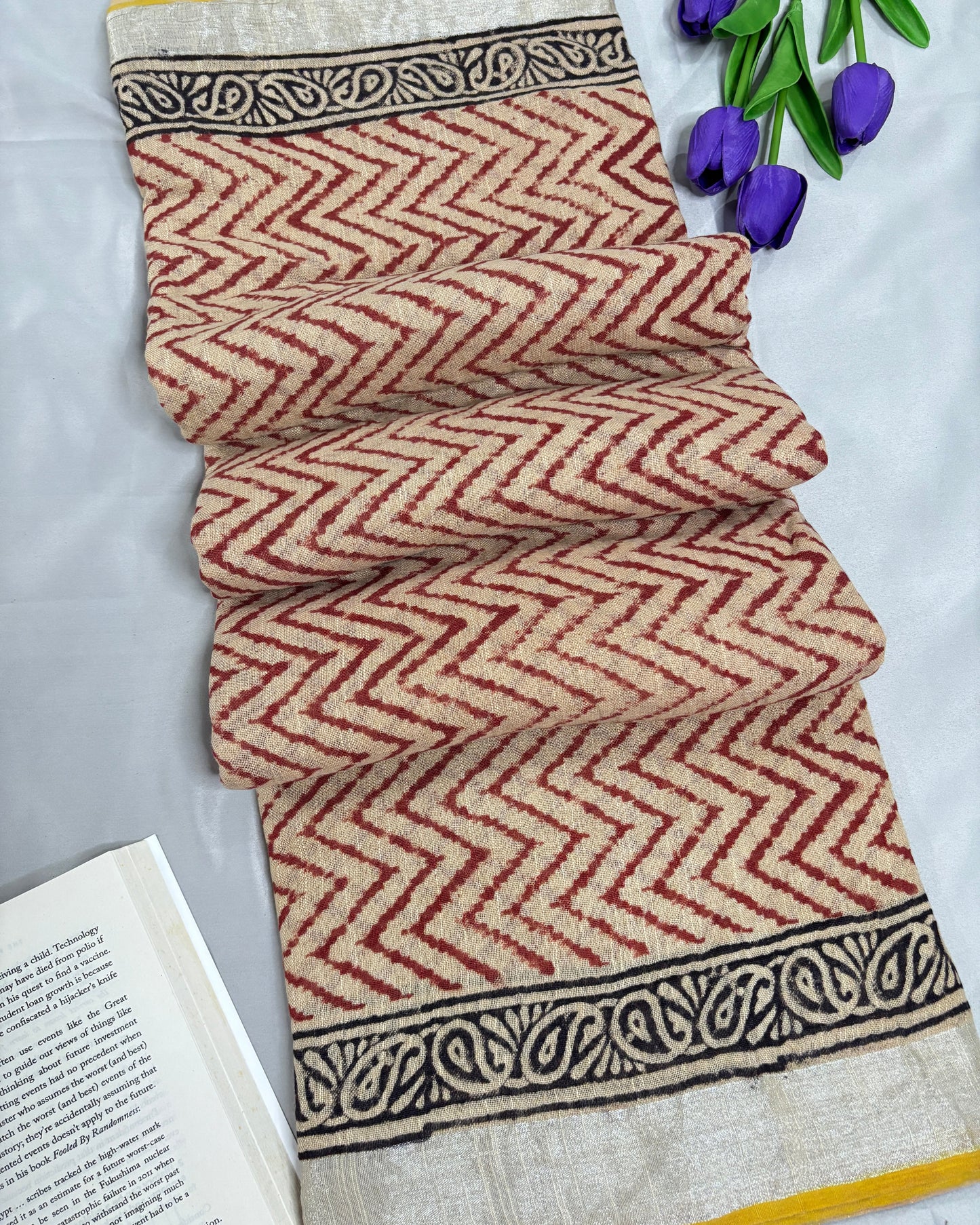 Linen saree with chevron pattern and border on a white background