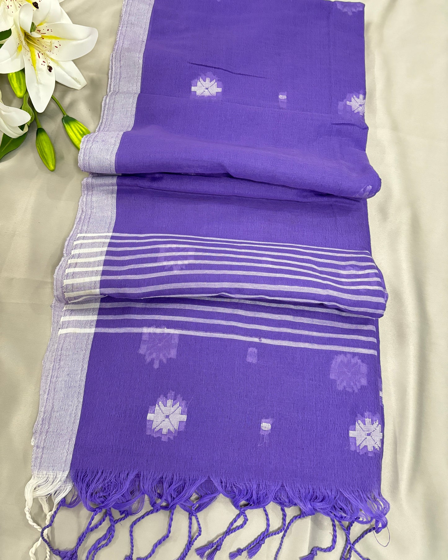 Purple saree with white patterns on a beige background