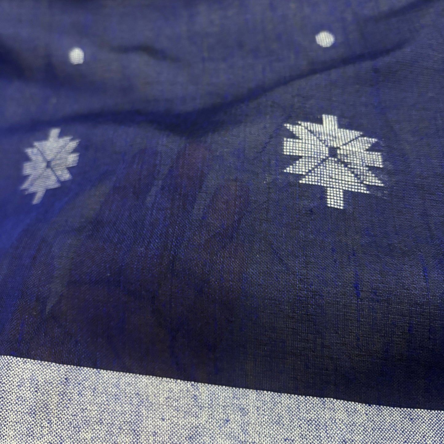 Blue cotton Saree  with white floral patterns on a wooden surface