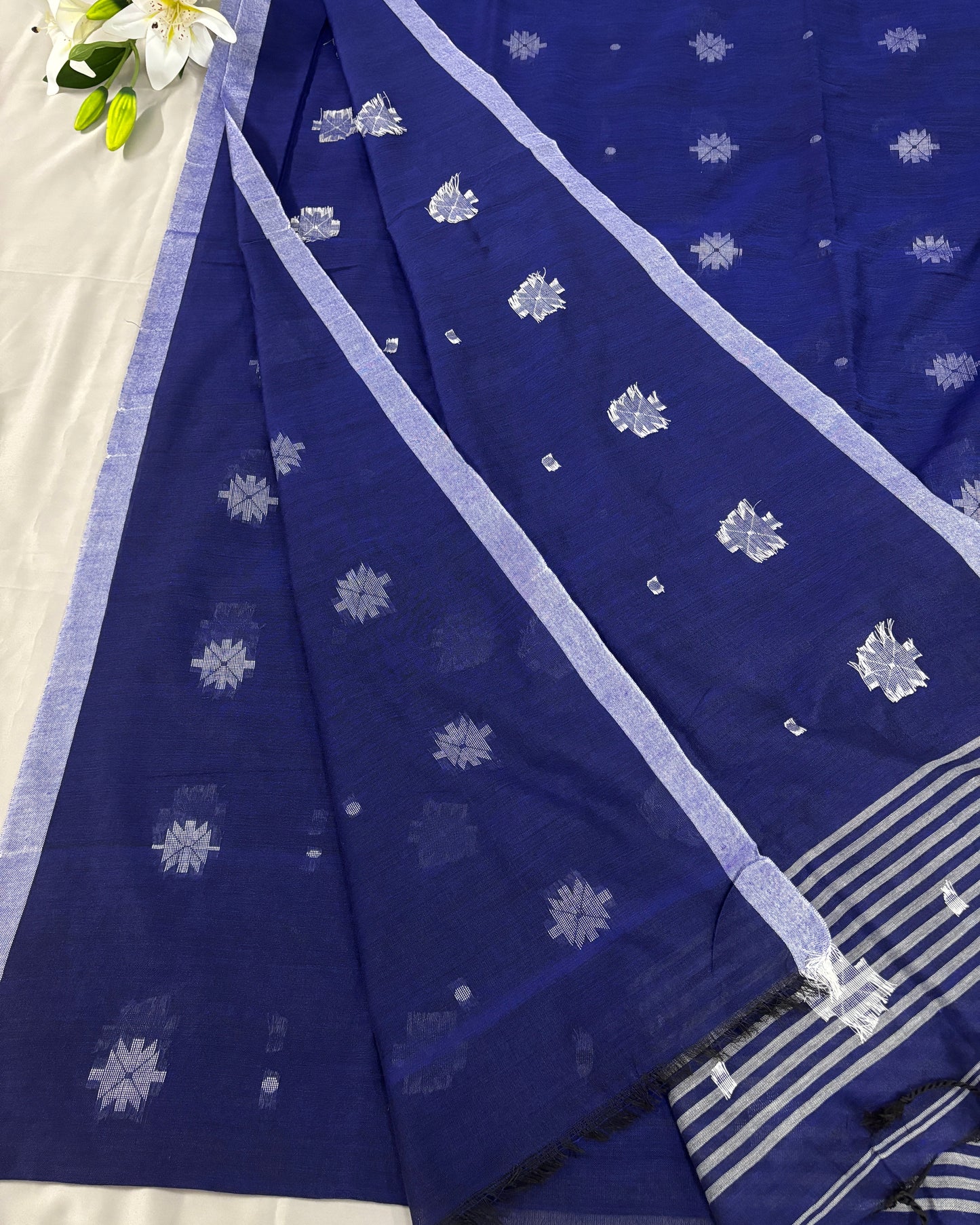 Blue cotton saree with white floral patterns on a white background