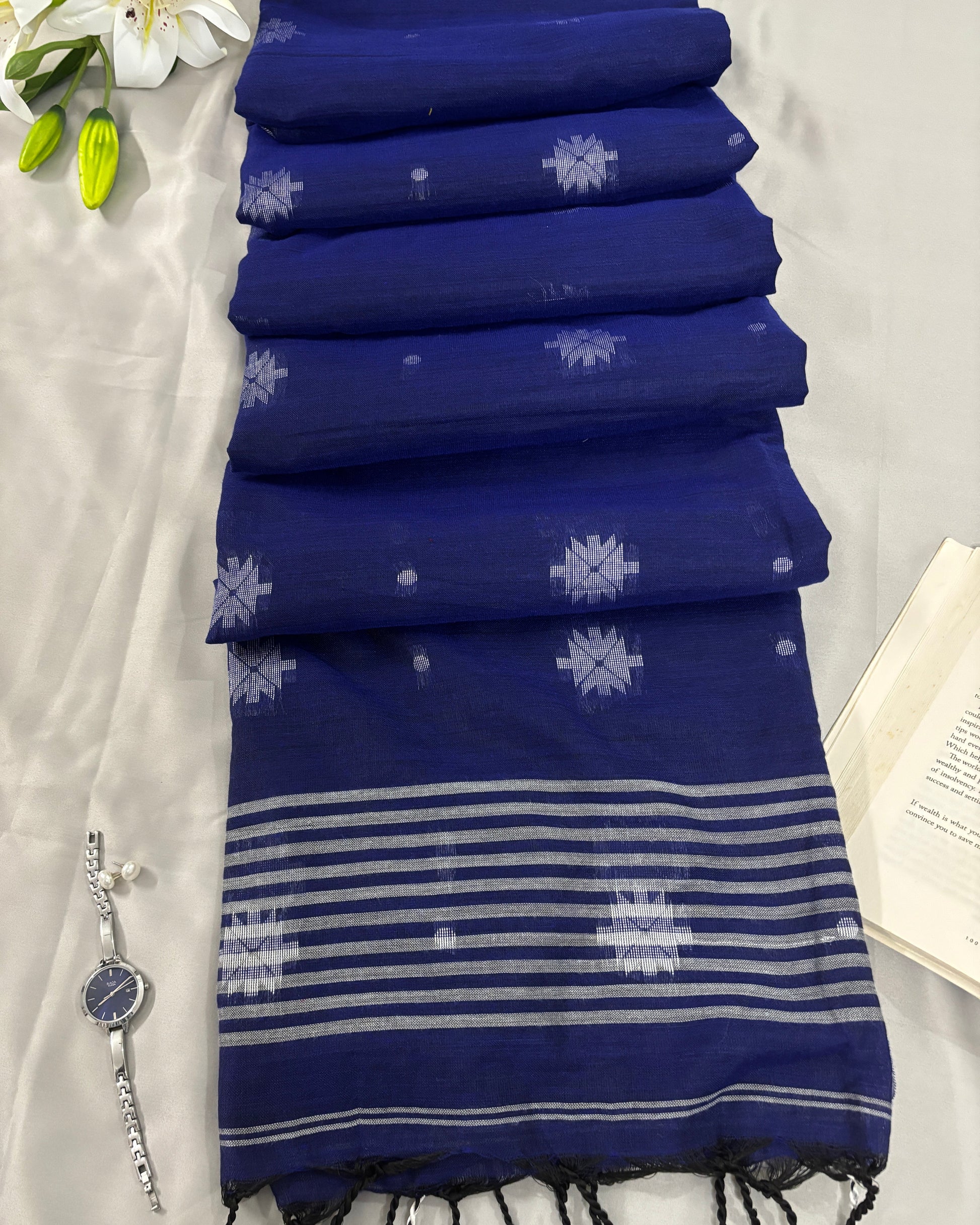 Blue pure cotton saree with white patterns on a light gray background