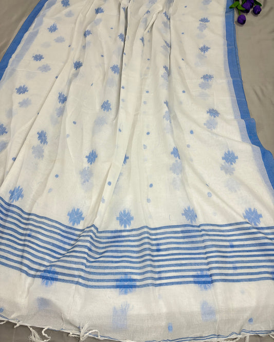 White Shuchi Label saree with blue floral patterns and stripes on pallu on a gray background
