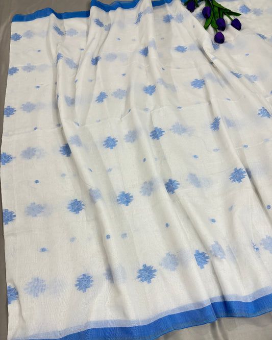 White saree with blue floral patterns on a gray background