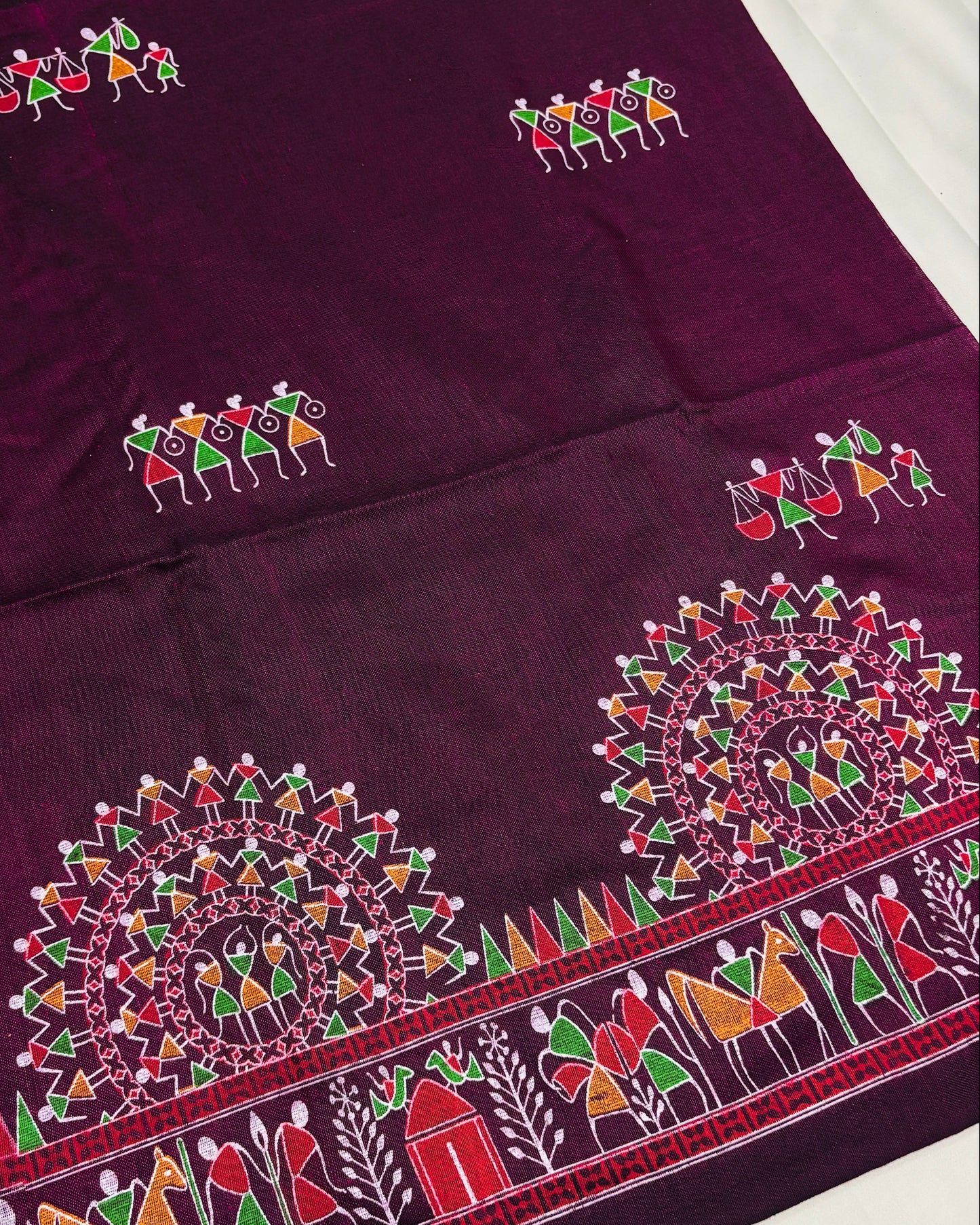 Purple saree with colorful madhubani prints on a white background