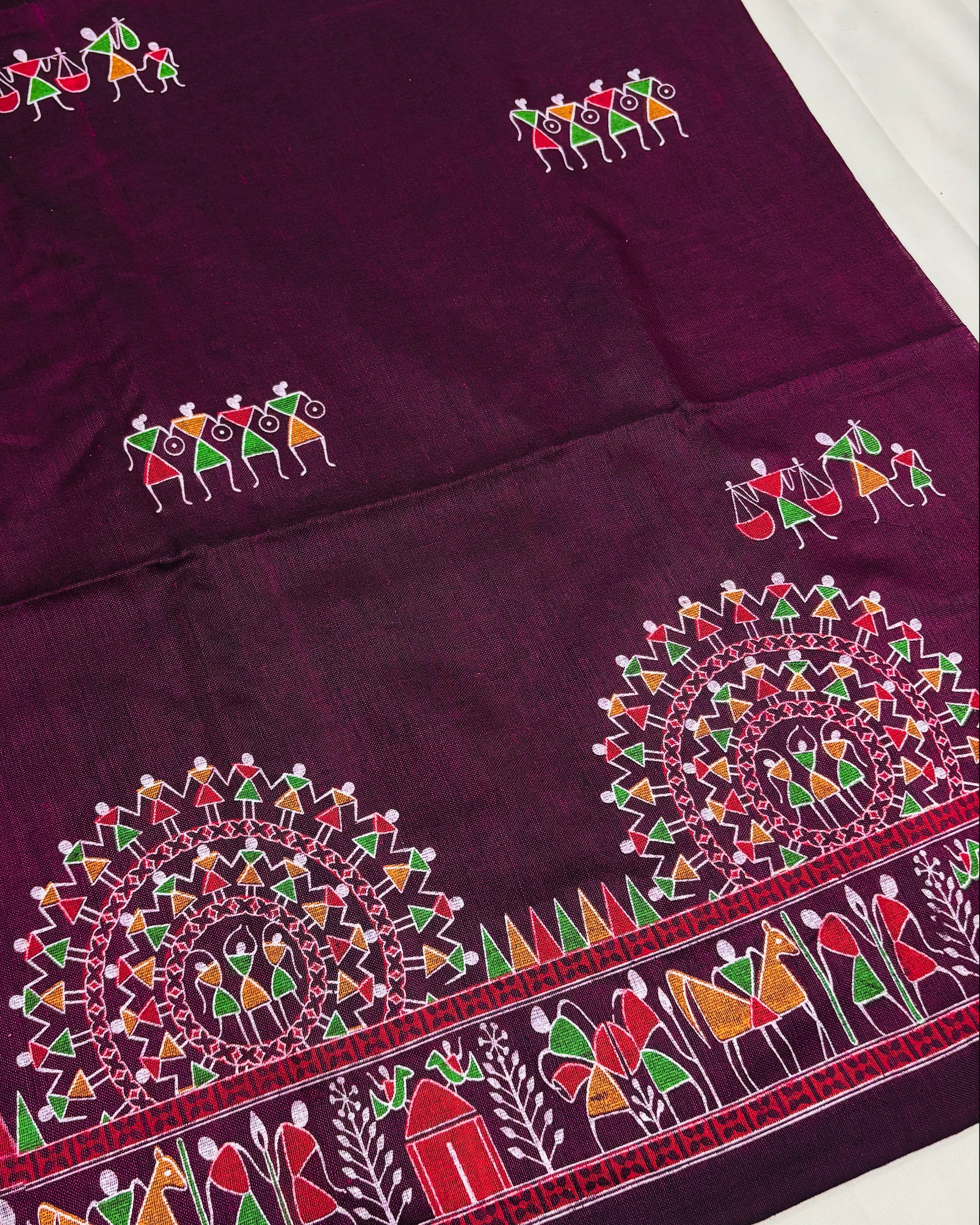 Purple saree with colorful madhubani prints on a white background